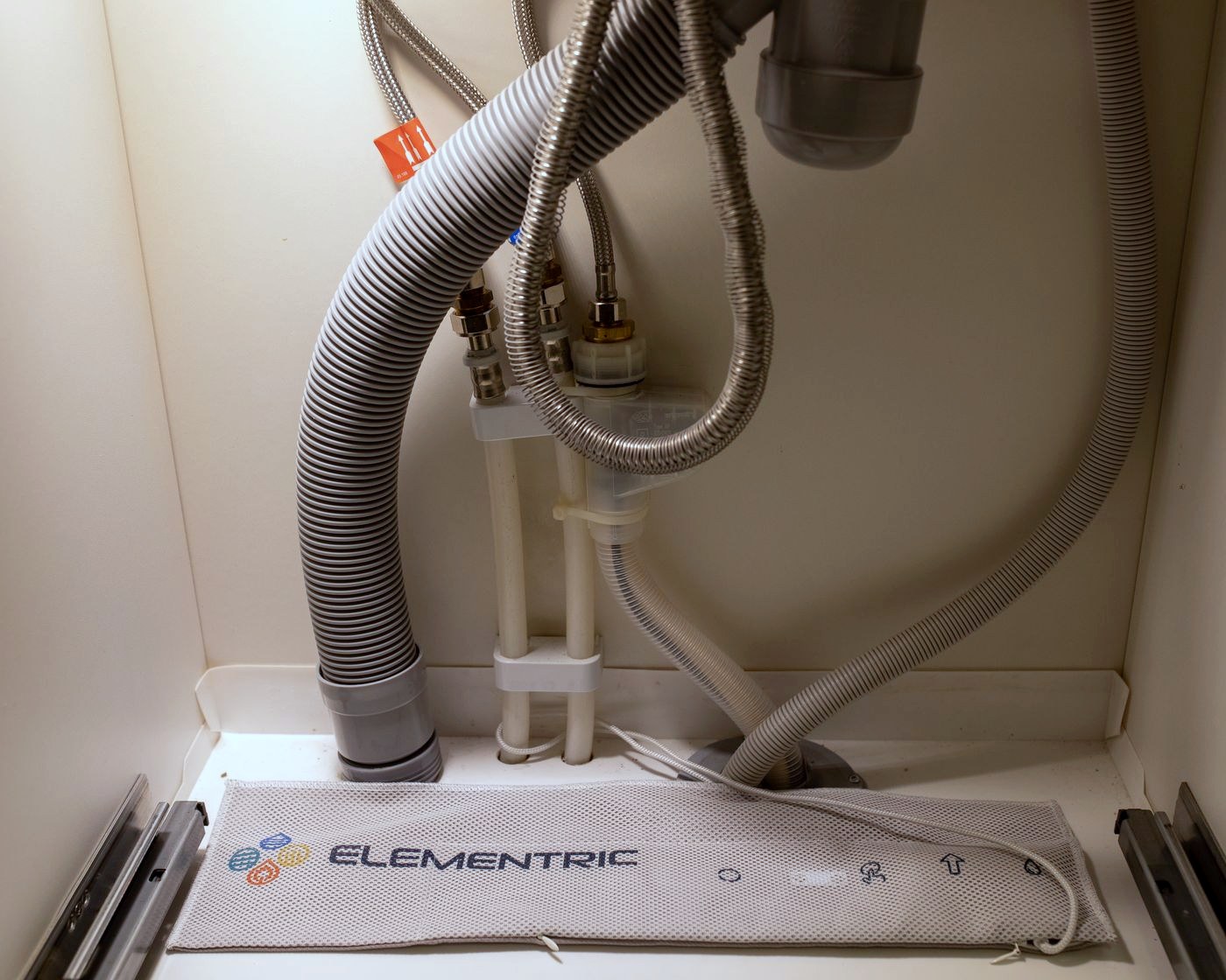 En Dripspy-måtte liggende fladt på gulvet i et vaskeskab